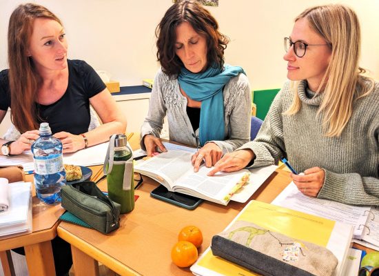 Kursteilnehmerinnen lernen mit Büchern